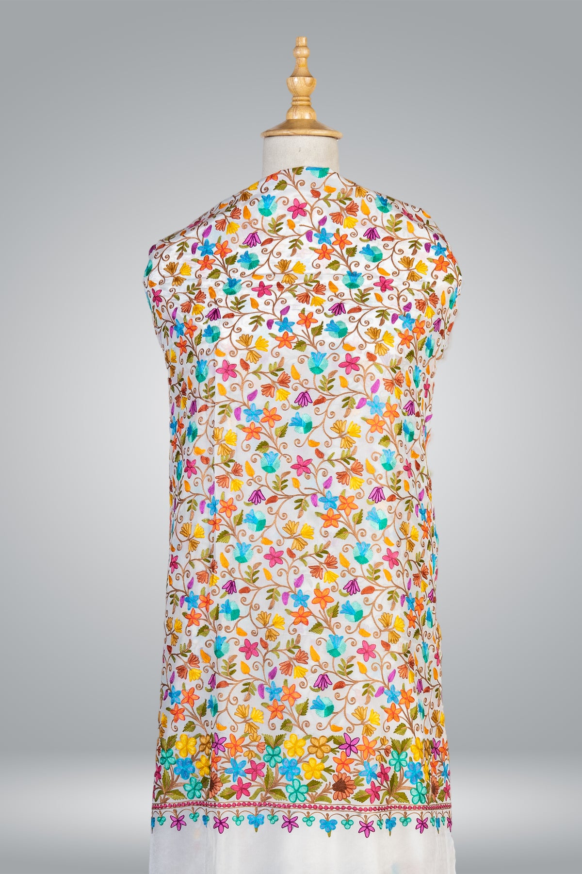 White saree pallu displayed on a mannequin, covered in colourful floral vines with a dense flower border and plain end.