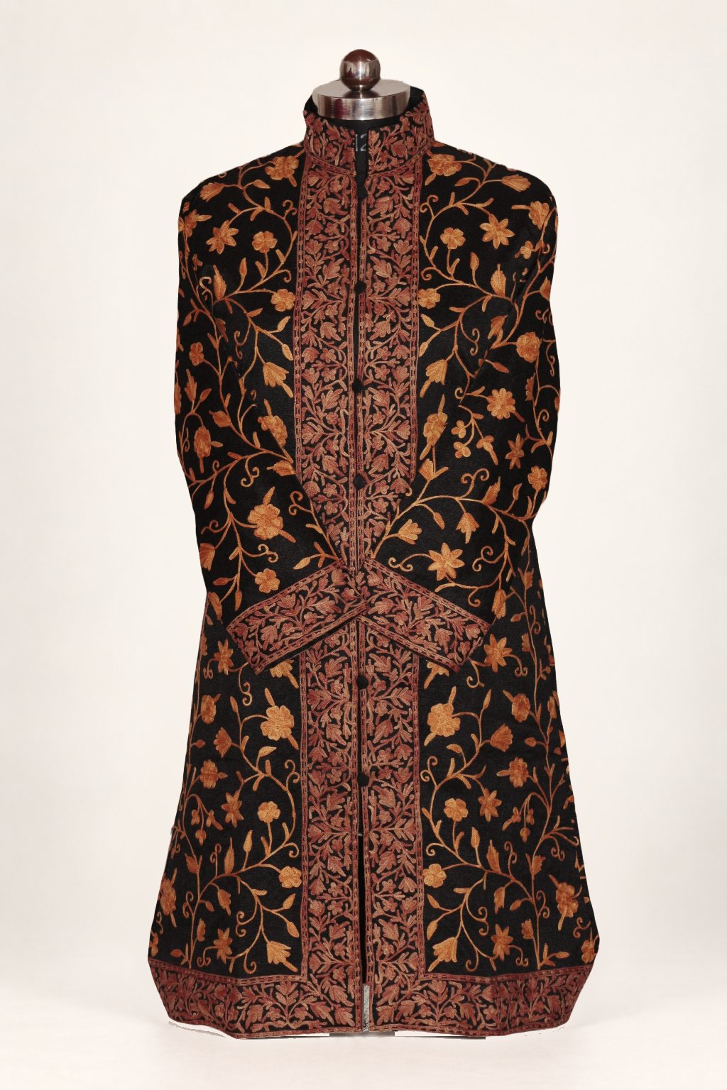 Front view of a black long coat with orange Aari floral vines, broad brown embroidered borders and crossed sleeves