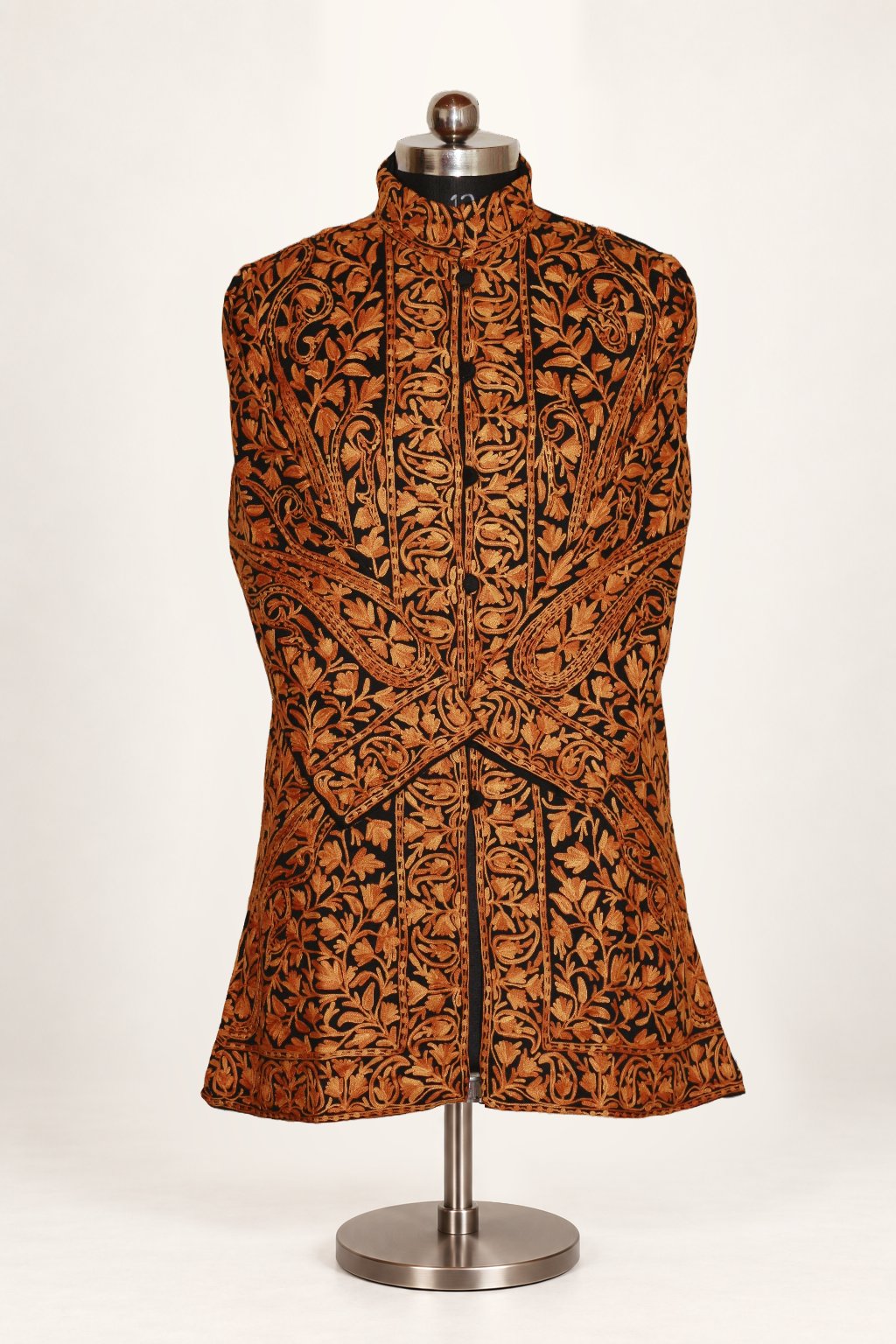 Front view of a black jacket with orange-brown Aari paisley and floral embroidery, a stand collar and crossed sleeves