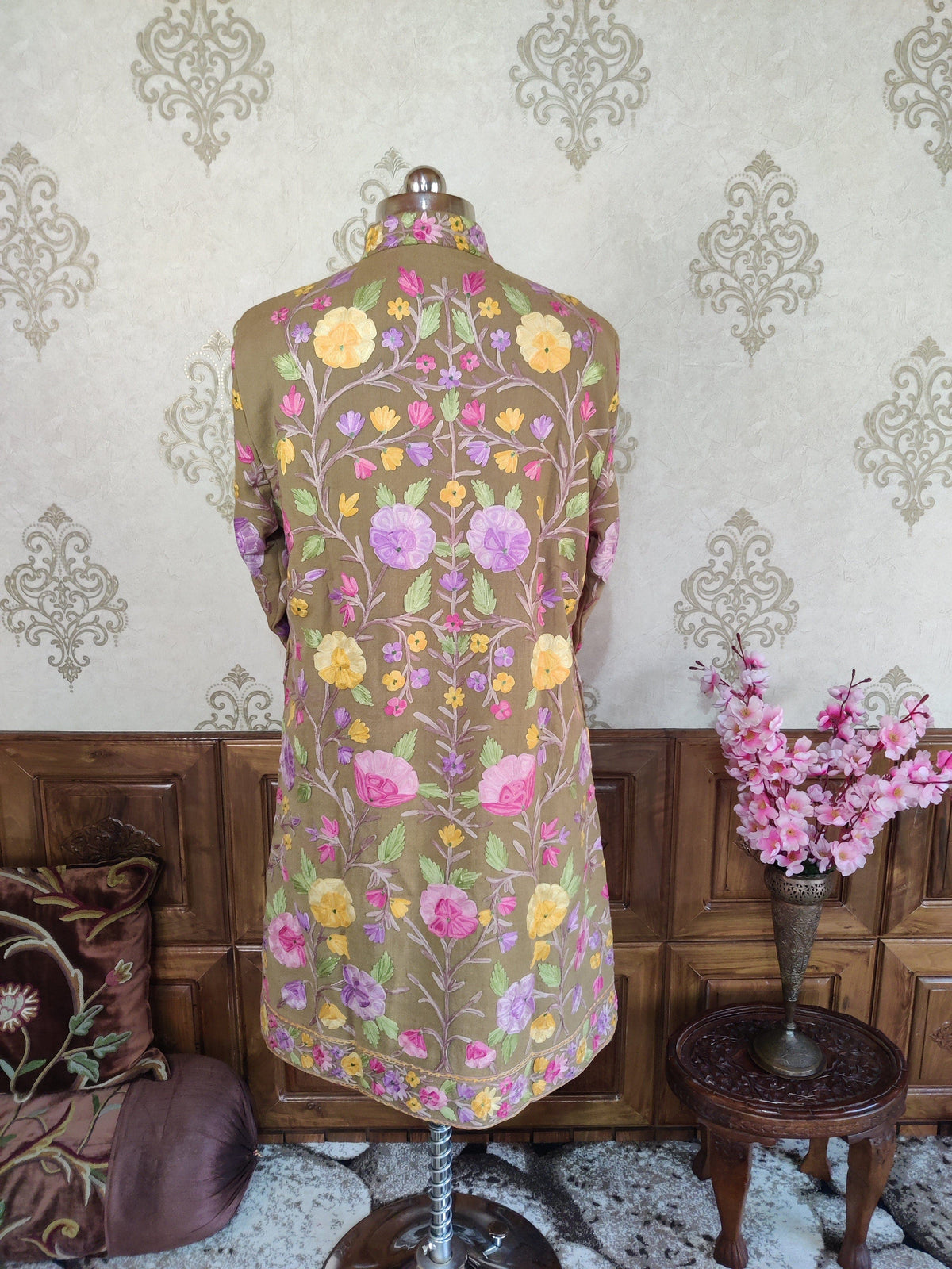 Back view of taupe long coat with symmetrical pink, lilac and yellow Aari floral vines and a narrow floral hem border