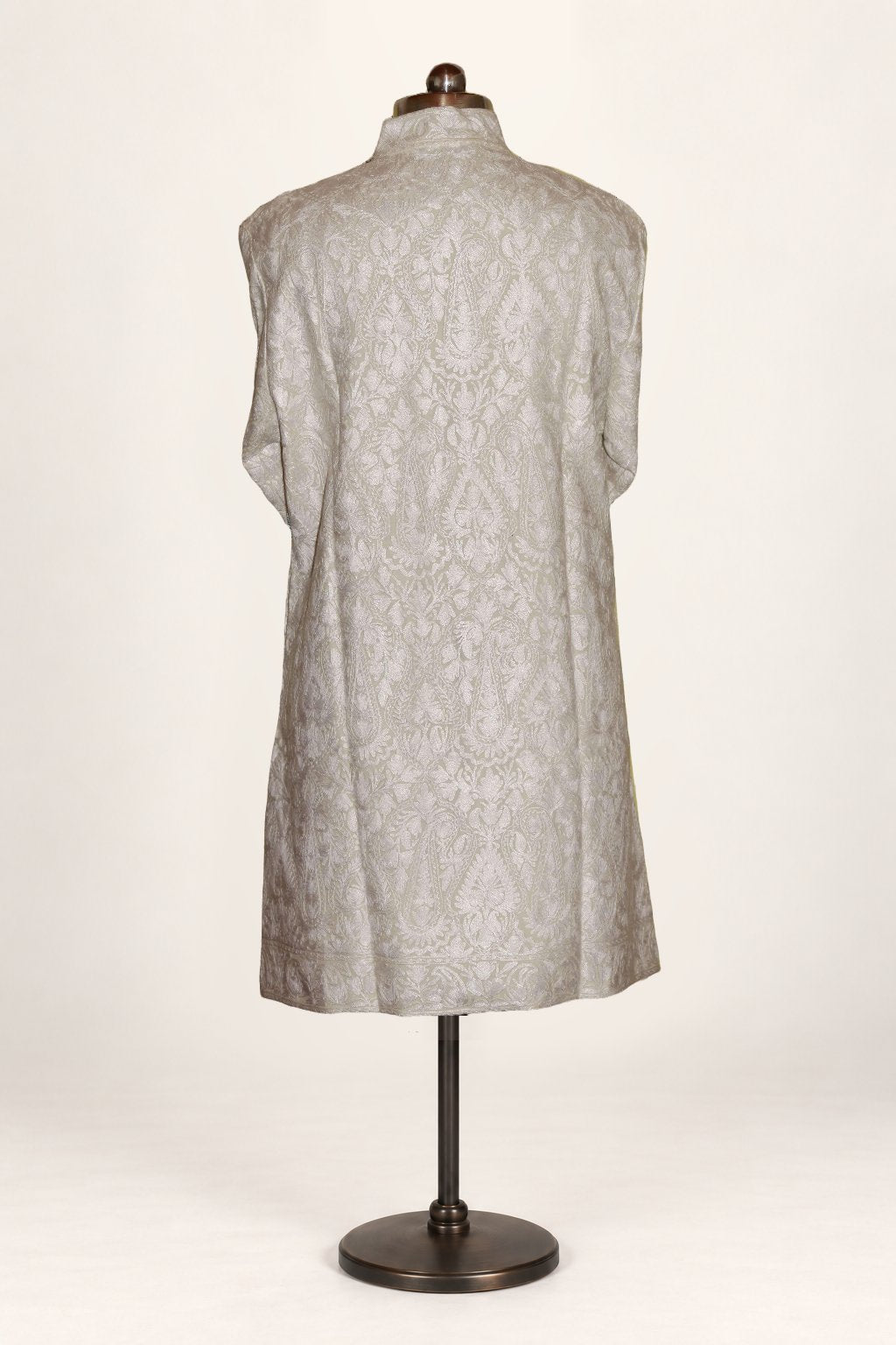 Back view of ivory-white long jacket densely patterned with tonal Aari floral and paisley embroidery