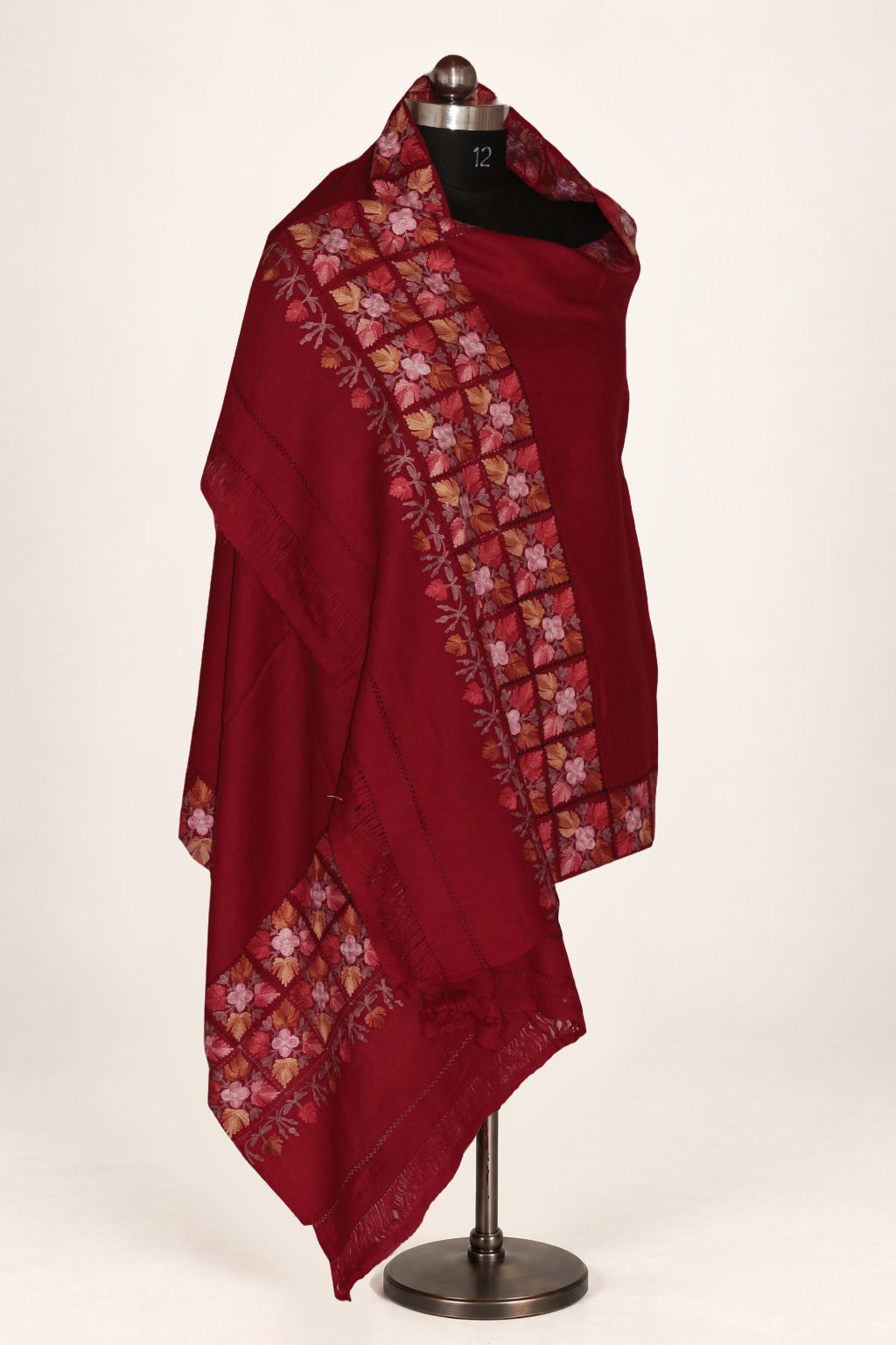 Maroon Merino wool stole draped on a mannequin, with floral Aari cutwork borders around a plain centre