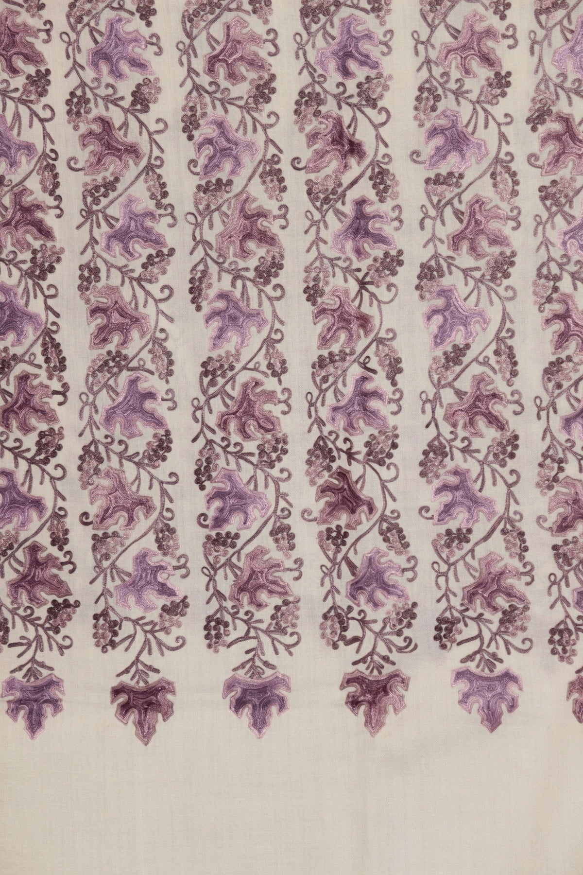 Detail of ivory Merino wool scarf with vertical bands of mauve Aari leaves and small flowers ending above a plain ivory strip