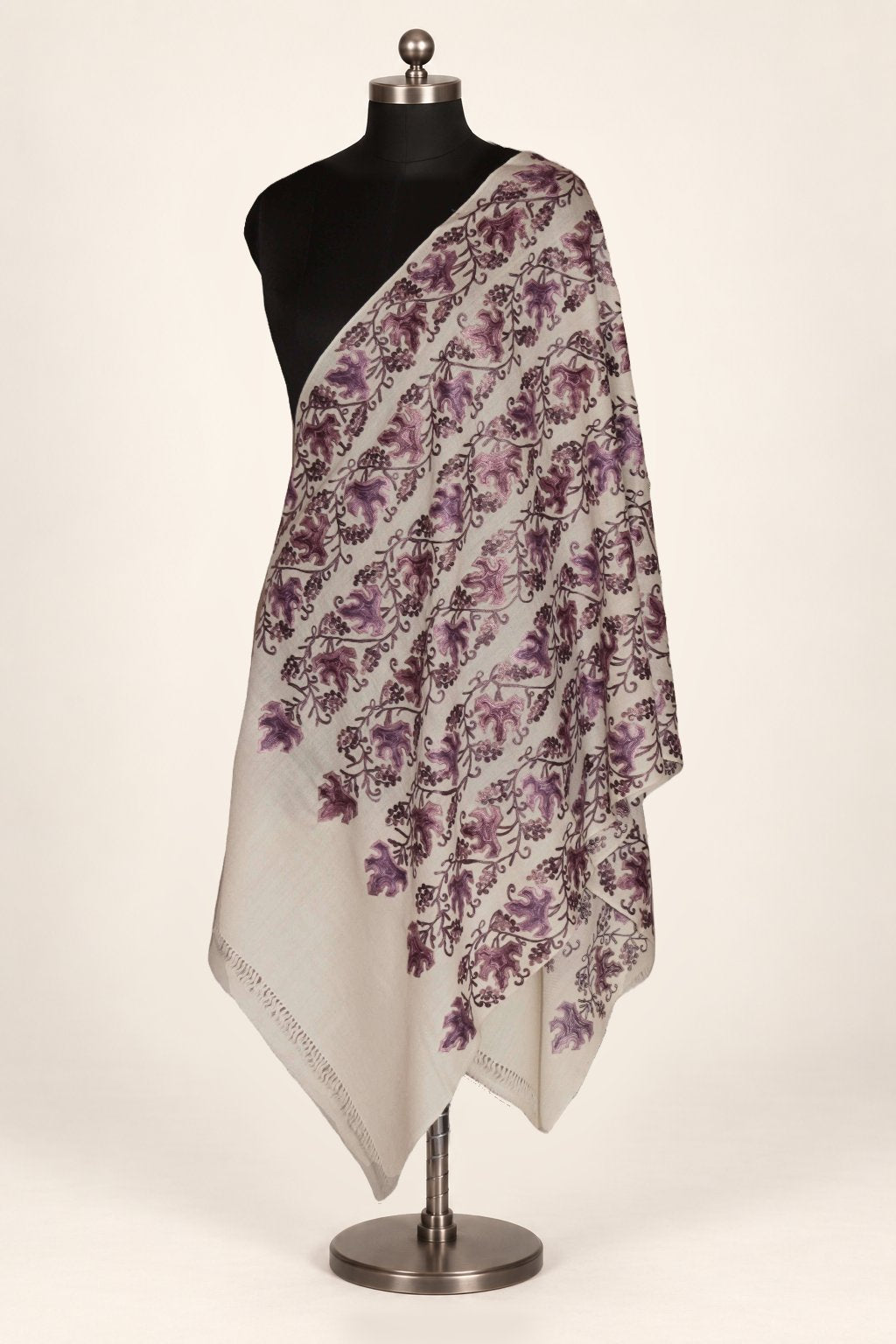 White merino wool stole draped over a mannequin’s shoulder, with dense purple Aari leafy vines and short fringed ends