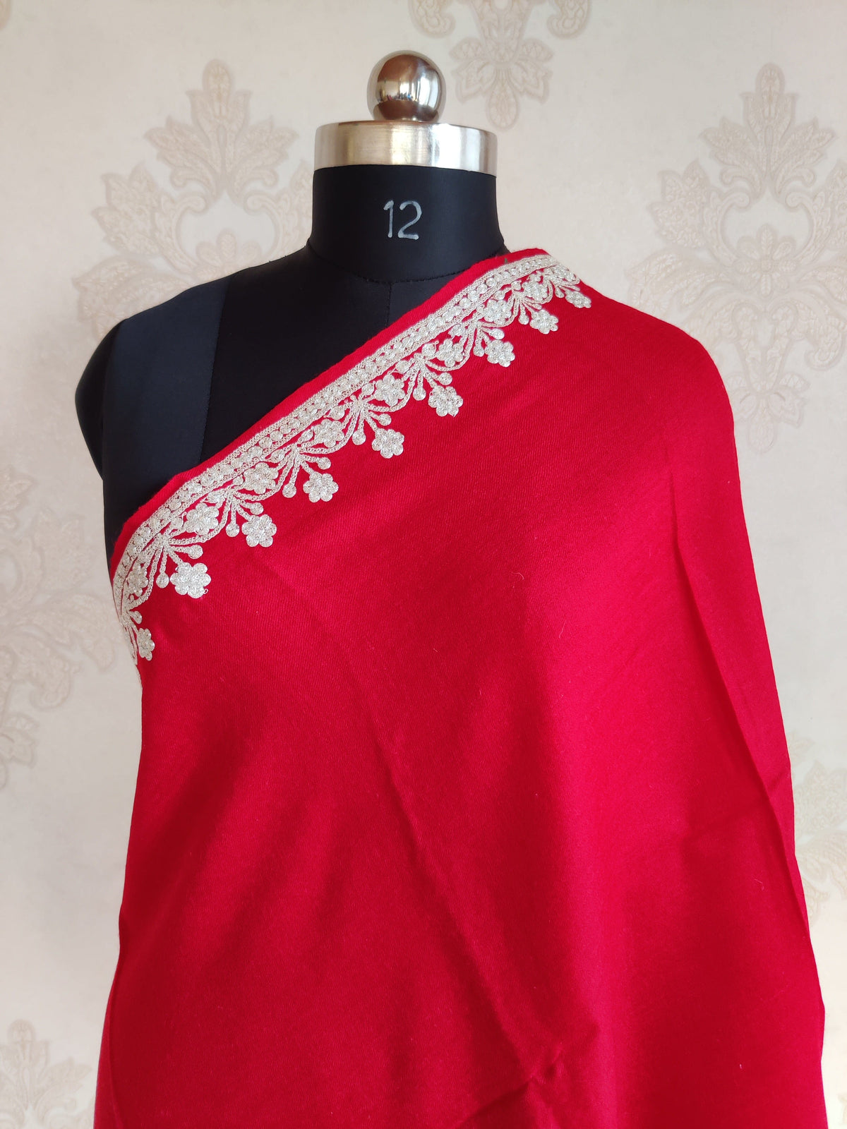 Upper drape of red Merino wool scarf on a mannequin, with a silver-toned Tilla floral border around a plain centre