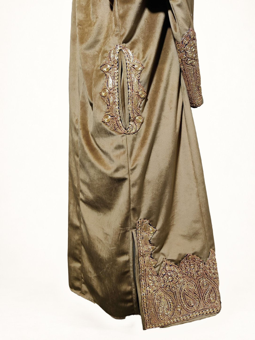 Side detail of a brown velvet pheran, with gold-toned Tilla embroidery around the pocket opening, cuff and lower side slit.
