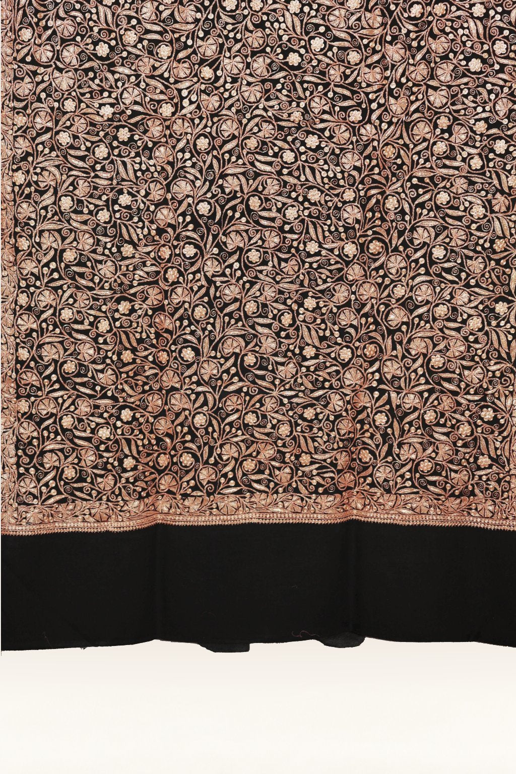 Black merino wool shawl laid flat, showing dense copper-toned Tilla flowers and curling vines above a narrow border and plain end.