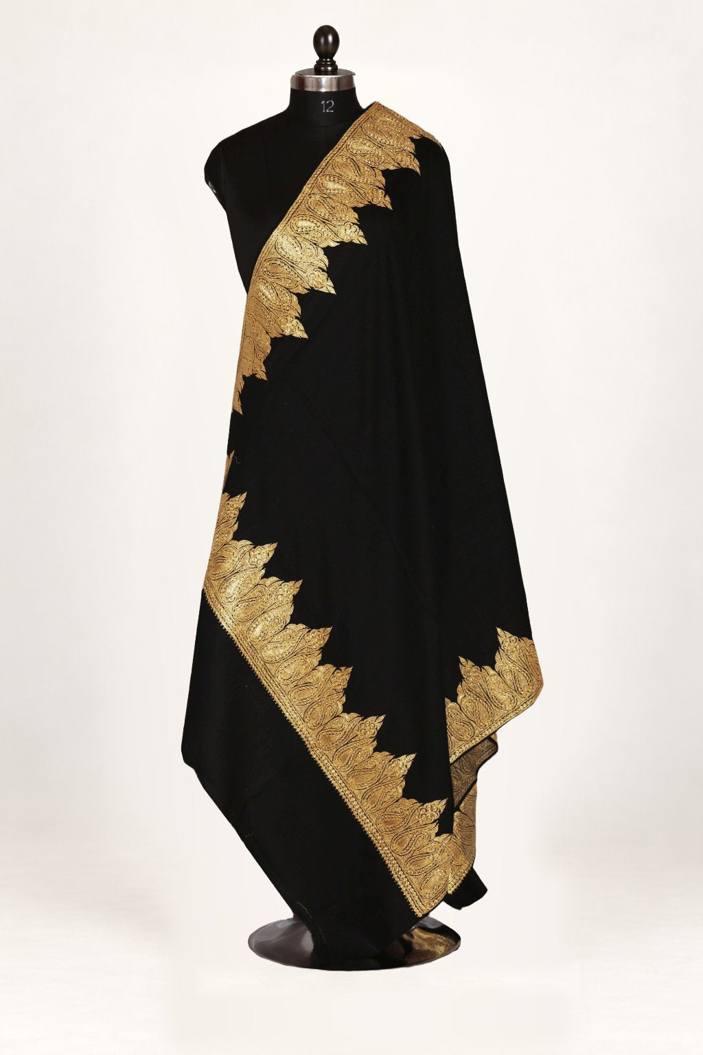 Black Merino wool shawl draped on a mannequin, with a wide golden paisley Tilla border around a plain centre