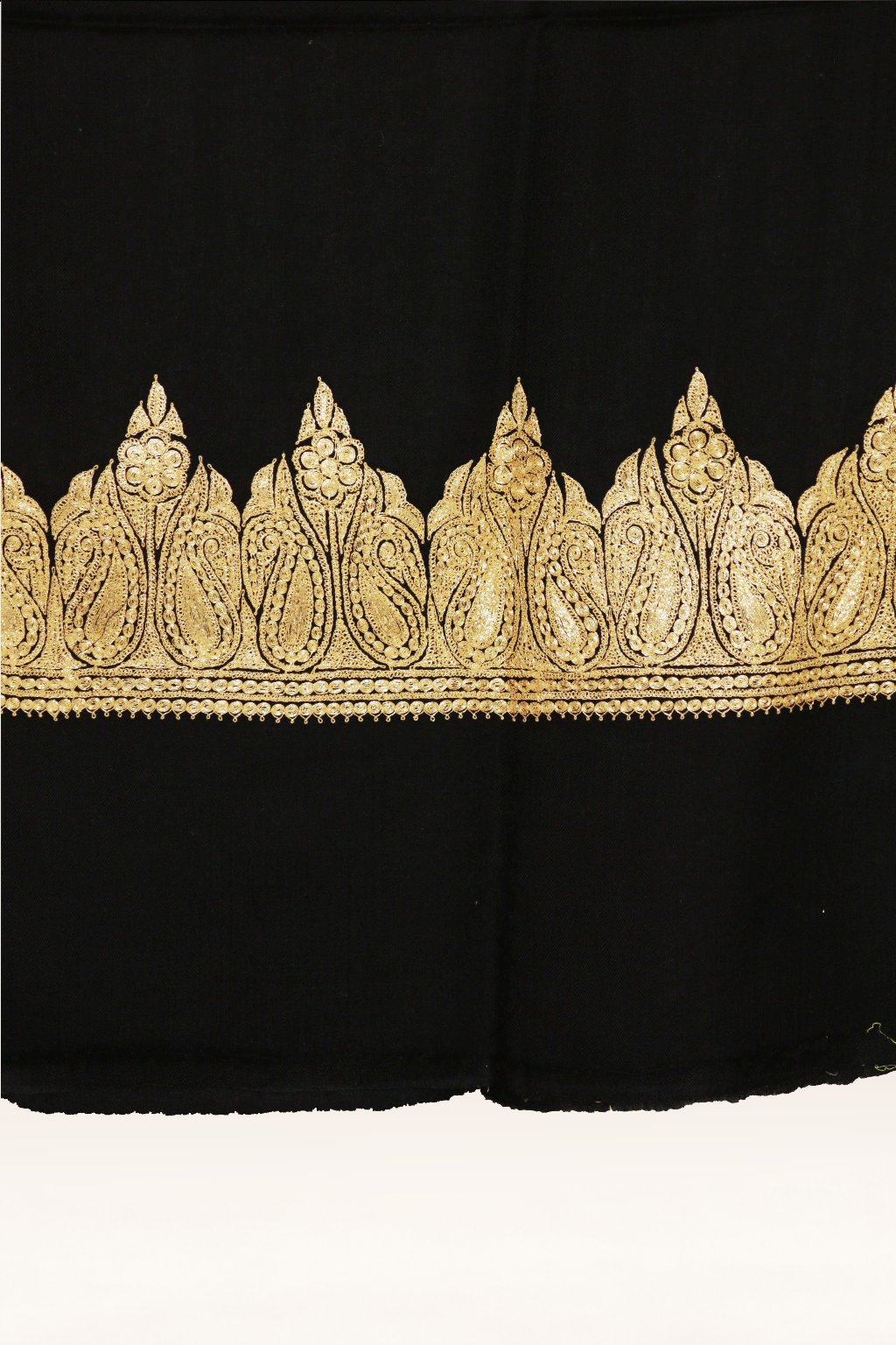 Close-up of the gold Tilla paisley border and narrow scalloped trim on a black Merino wool shawl