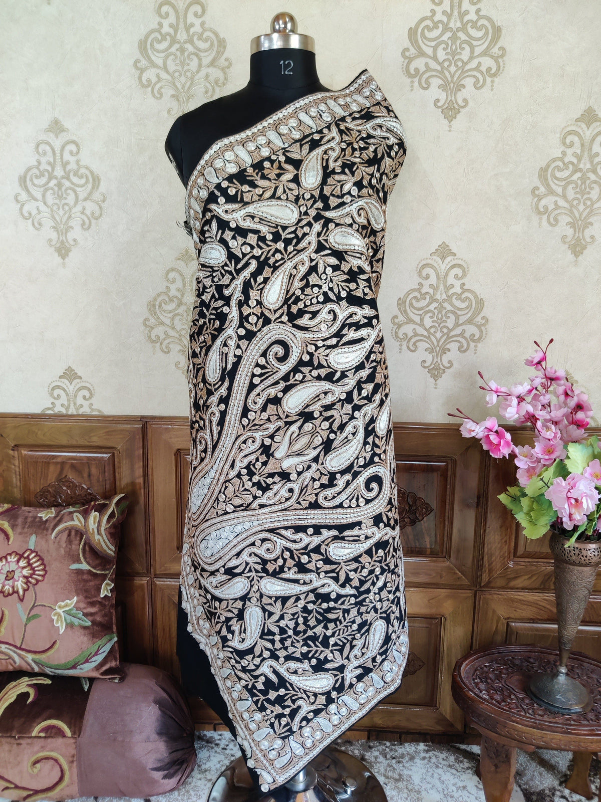 Full-length view of the black Merino wool shawl wrapped closely around a mannequin, showing large paisley motifs