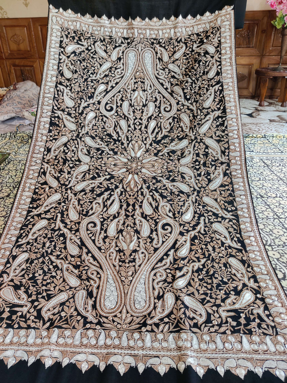 Black Merino wool shawl spread open, revealing its complete symmetrical paisley Tilla pattern and embroidered borders