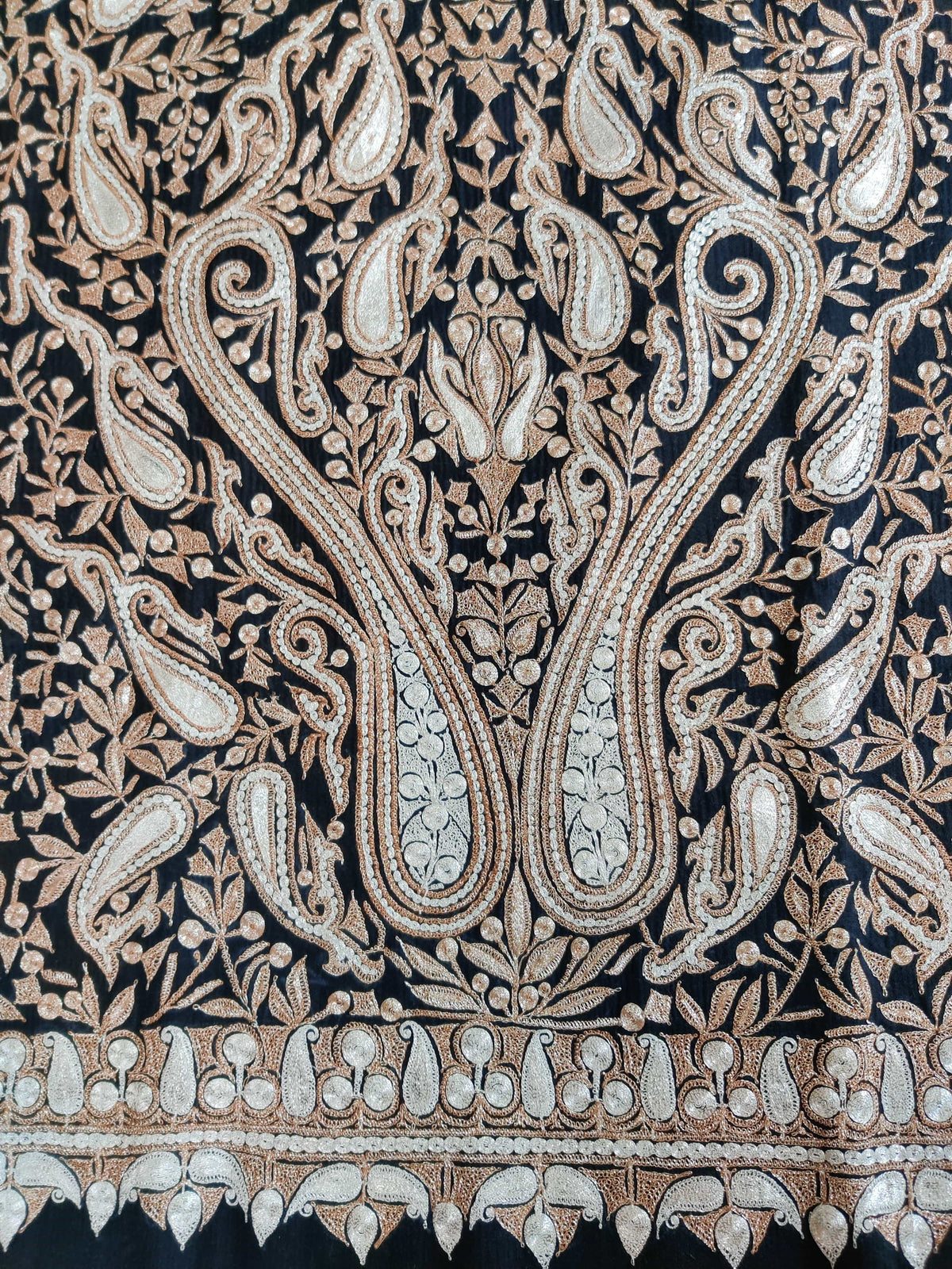 Close-up of paired paisley motifs and the teardrop-patterned lower border on the black Merino wool shawl